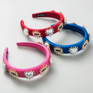 Macro detail of handmade satin headband with crystal heart pearls and evil eye metal charms