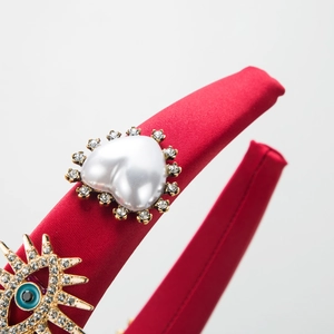 Red satin headband with heart pearl and blue devil eye rhinestone embellishments