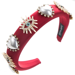 Close-up of burgundy satin headband with luxury pearls and Evil Eye rhinestone details
