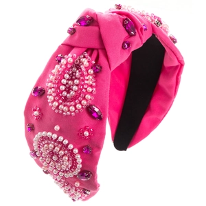 Pink knotted headband with hand-sewn pearls and fuchsia gemstones on glossy fabric