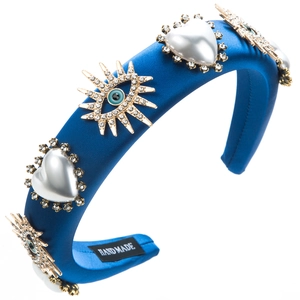 Detailed macro view of handmade blue satin headband with pearls and evil eye charm