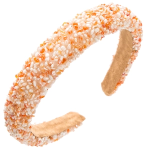 Detail eines gepolsterten Stirnbands mit weißen und orangen Steinen und Wildlederfutter