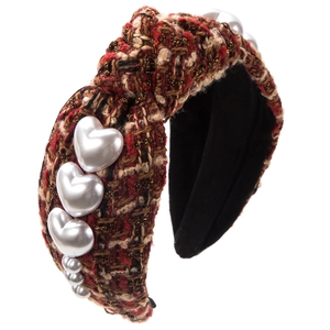 Close-up of knotted bouclé headband with heart pearls and elegant tweed texture