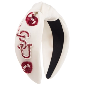 Detail view of handcrafted beaded embroidery on white fabric headband with knot design