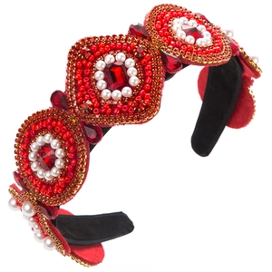 Macro detail of red Baroque headband with faceted gemstones, pearls and intricate beadwork