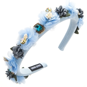 Detail eines handgefertigten hellblauen Haarreifs mit Stoffblumen und Glitzerschmuck