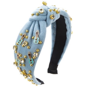 Détail du serre-tête en velours bleu avec pendentif violon et strass brillants