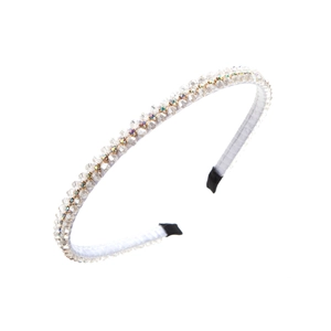 Dettaglio del cerchietto sottile con cristalli chiari e strass colorati su sfondo bianco