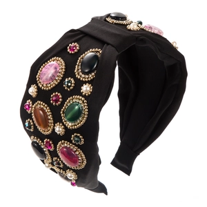 Close-up of bohemian wide knotted headband with colorful gemstones and pearls