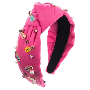 Detail van roze geknoopte haarband met emaille gitaren, parels en strass steentjes