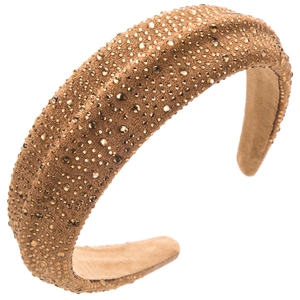 Close-up of luxury brown velvet headband with sparkling gold rhinestones and soft texture
