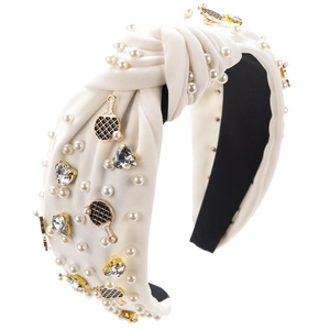 Détail d'un serre-tête noué orné de perles blanches et de breloques raquettes de tennis