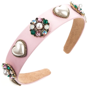 Makro-Detail von rosa Satin-Stirnband mit Herzperlen und bunten Strass-Blumenverzierungen