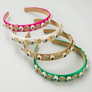 Detail of four colorful headbands with Evil Eye and Tree of Life metal ornaments