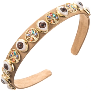 Detailed view of bohemian brown fabric headband with evil eye and tree of life gold charms