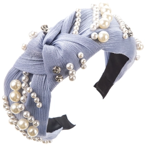 Elegant light blue knotted headband with faux pearls and rhinestones on white background