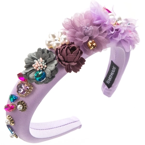 Detail of handmade baroque headband with purple fabric flowers and sparkling crystals