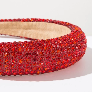Close-up of luxury red rhinestone headband with sparkling crystals and padded sponge texture