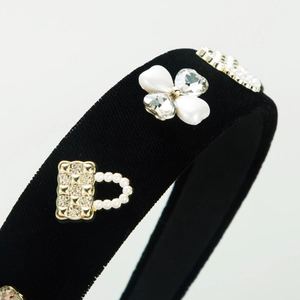 Elegant black velvet headband featuring a pearl-studded gold handbag charm and diamonds