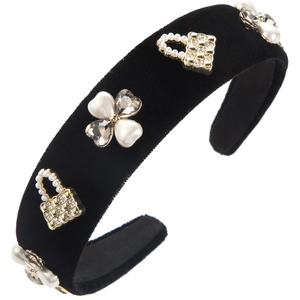 Detailed macro of black velvet headband with gold pearl charms and rhinestone flowers