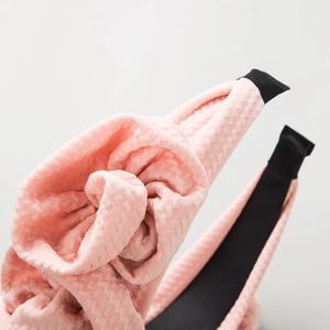 Light pink bubble knit fabric headband featuring a large handmade fabric rose flower