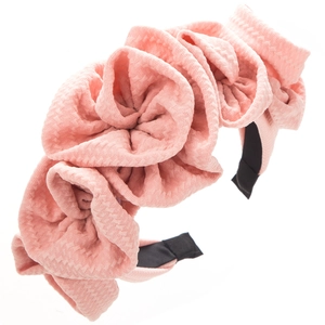 Detail of pink ruffled fabric flower headband showing intricate woven texture and craftsmanship