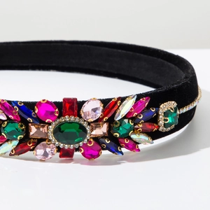 Detailed close-up of velvet headband with colorful emerald and ruby faux gemstones