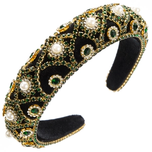 Close-up of sparkling rhinestones and white pearls on a black velvet baroque headband