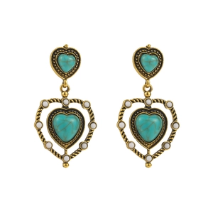 Detail of bohemian gold earrings with turquoise heart stones and white beaded accents