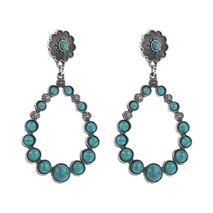 Detailed macro view of vintage bohemian heart drop earrings with turquoise stones