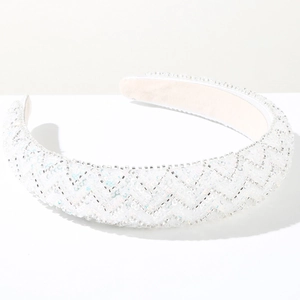 Detailed view of white handmade beads and sequins on wide sponge headband with geometric patterns