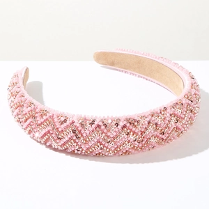 Detail of pink beaded sponge headband with hand-sewn golden wave patterns and velvet lining