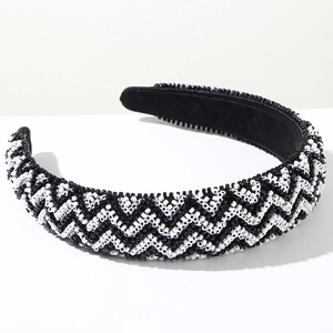 Detail showing hand-beaded black and white wave pattern on a wide padded headband