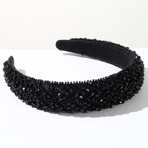 Détail d'un serre-tête noir avec perles artisanales et cristaux facettés sur un fond blanc pur