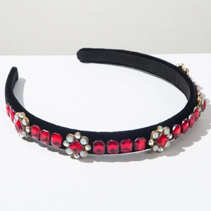 Detailed close-up of velvet headband with red square gems and floral crystals