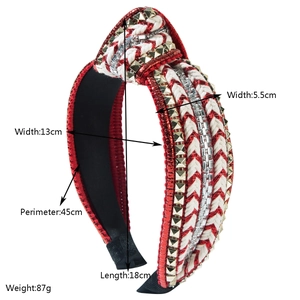 Red and white woven headband with gold pyramid studs and a stylish top knot design