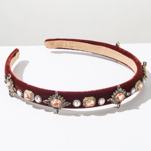 Detailed shot of burgundy velvet headband with vintage crystals and orange gemstones
