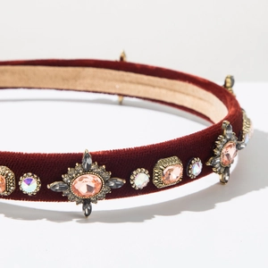 Detail of burgundy velvet headband with pink gemstones and gold vintage metallic settings