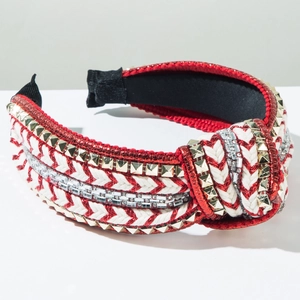 Detail of red and white braided headband with gold rivets and sparkling rhinestones