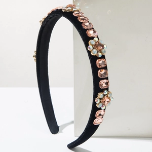Macro detail of black velvet headband featuring square champagne gems and floral crystals