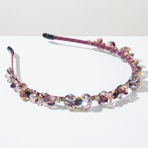 Macro detail of handmade crystal headband with purple satin and multi-color faceted stones