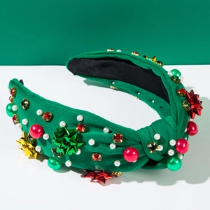 Detail eines Weihnachts-Haarreifens aus grünem Strick mit Perlen und Schleifenakzenten