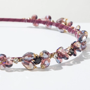 Macro shot of purple crystal headband with golden settings and fine fabric wrap