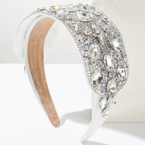 Macro detail of luxury baroque headband featuring sparkling crystals on white satin fabric