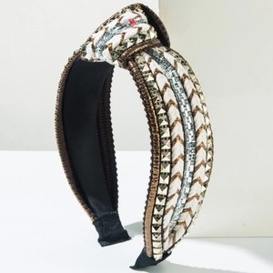 Knotted wide headband with rhinestones, gold studs and white braided ropes on brown fabric