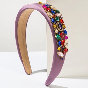 Détail d'un serre-tête rembourré de luxe avec strass colorés sur satin violet