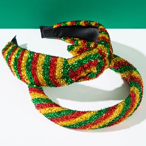 Close-up of sparkling Christmas headbands in red, green, and gold glitter stripes