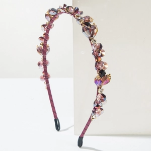 Baroque style thin headband with purple crystals and gold beads on a white display block