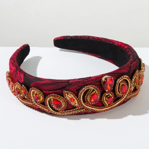 Close-up of vintage baroque headband with red gems and gold embroidery on sponge base