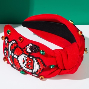 Gros plan sur le bandeau noué rouge avec broderie de perles et strass scintillants